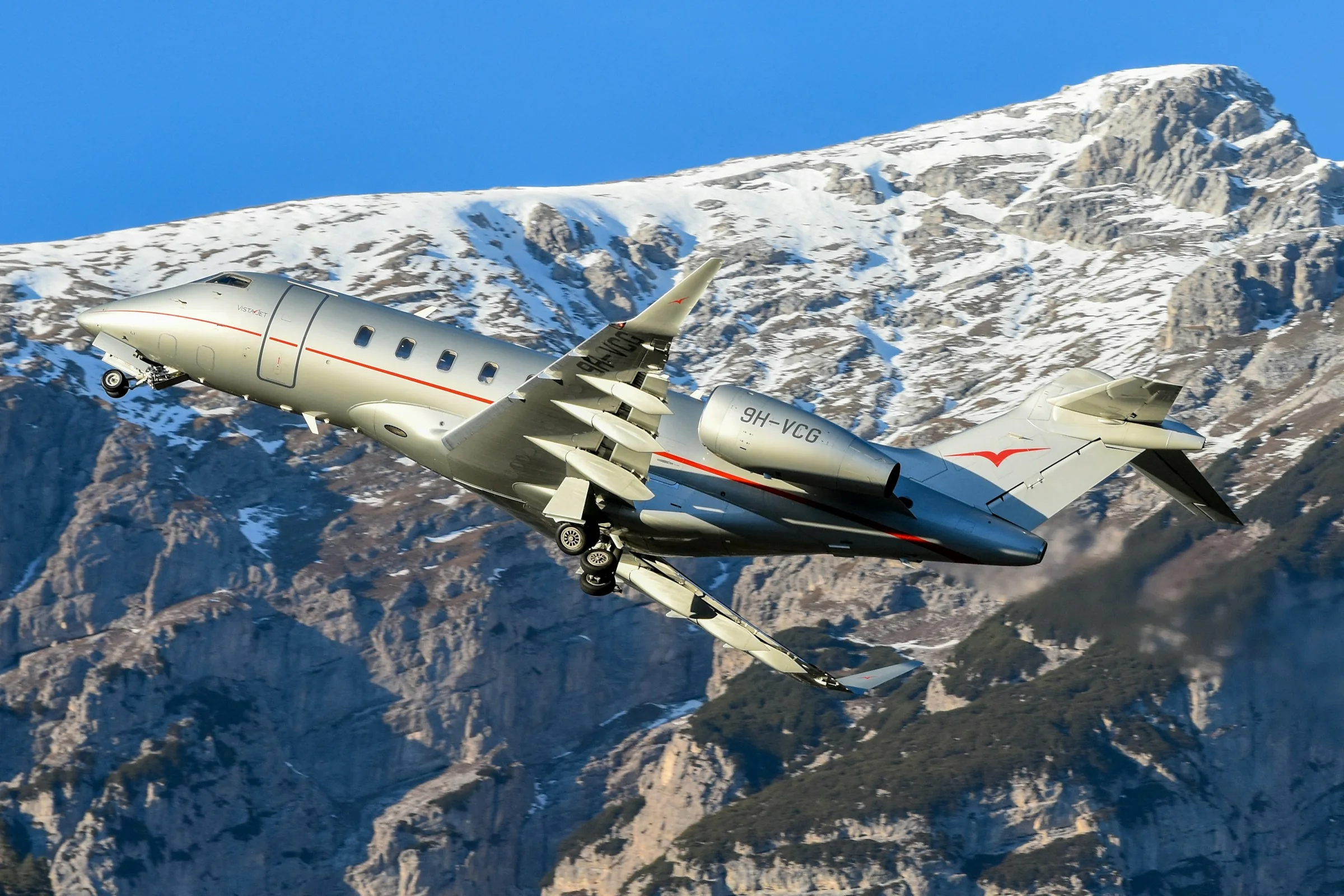 Jet privé en vol devant les sommets enneigés des Alpes à Innsbruck